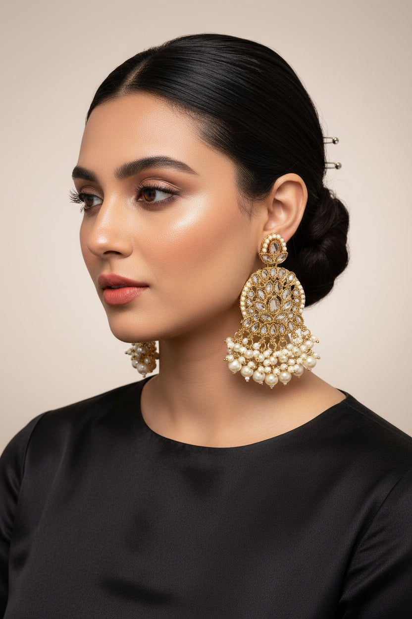 Ornate earrings with gold detailing and pearl beads on a model
