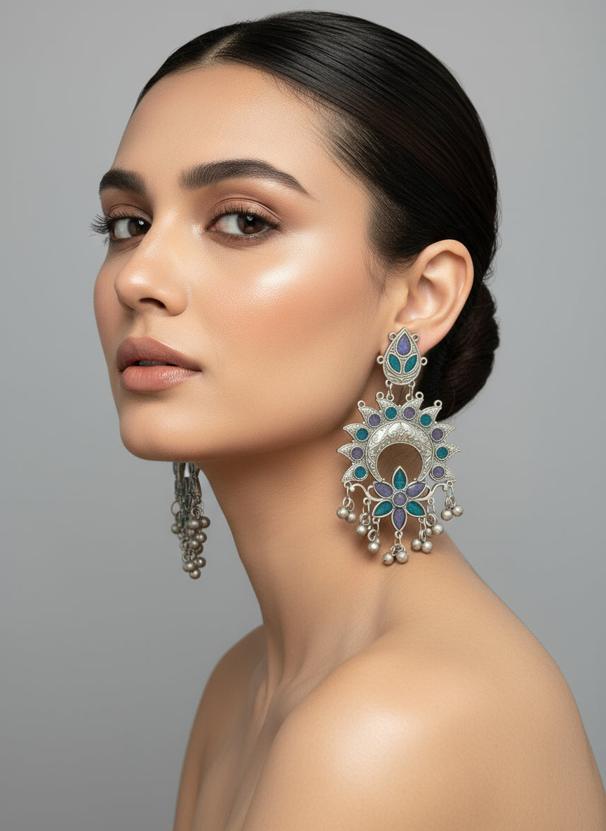 Woman wearing elaborate earrings against a gray background