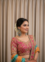 Pair of silver earrings with floral designs and green and purple stones on a light grey background