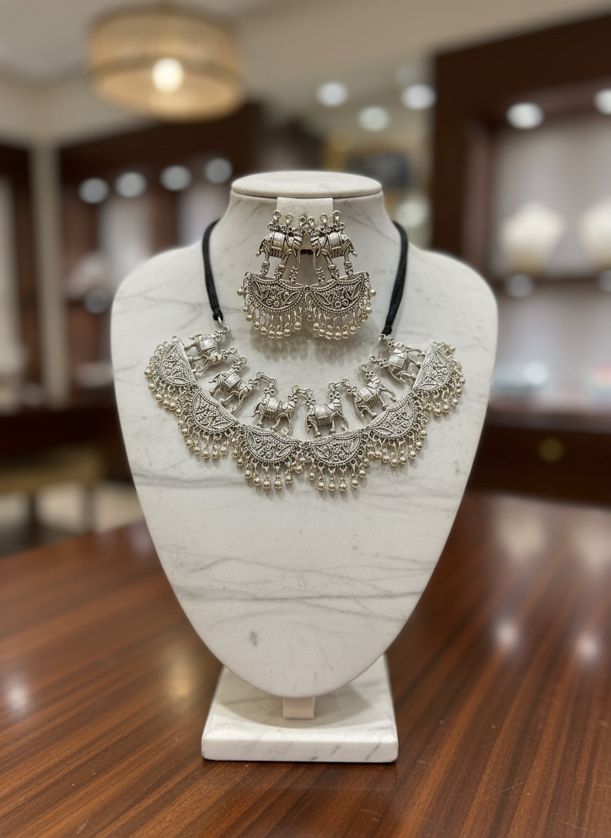 Silver jewellery set with necklace and earrings on a black stand