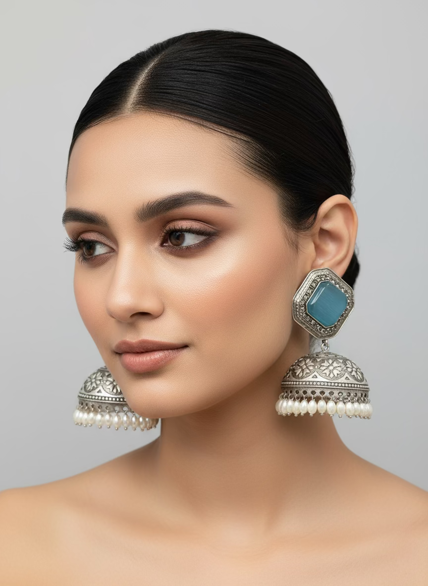 Pair of silver jhumka earrings with blue stone