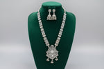 Oxidised long necklace with a pendant in the bottom and small jhumkey earrings with flower stud on top of the jhumkey.