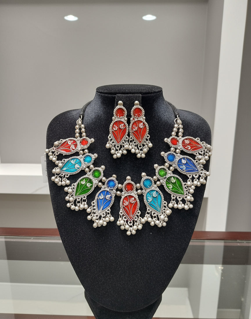 Colourful gemstone earrings on a black stand with a blurred background