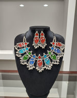 Colourful gemstone earrings on a black stand with a blurred background