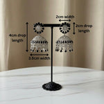 Pair of American diamond earrings with black stone on a stand with measurements indicated.