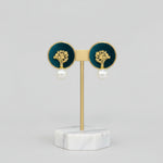 Pair of earrings with gold tops and pearl bottoms.