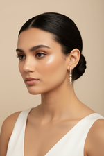 Model is wearing these earrings Pair of rose gold hoop earrings featuring a sparkling dangling chain of crystals.