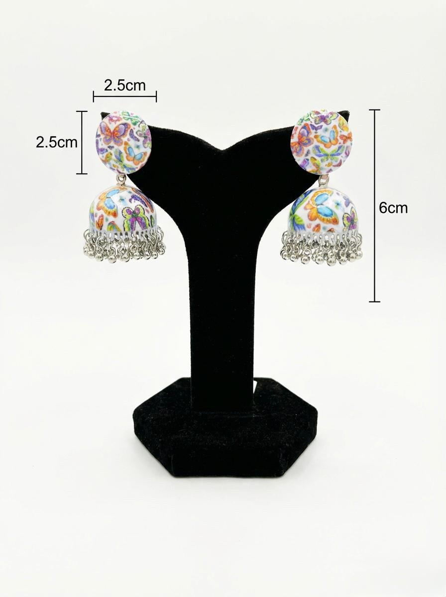Pair of hand-painted white enamel jhumka earrings with a butterfly motif and dangling metallic beads. with easurments.