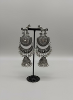 Pair of silver oxidised earrings with deer figure on the stud and chaand bali in drop with small jhumka in the bottom by famaza couture