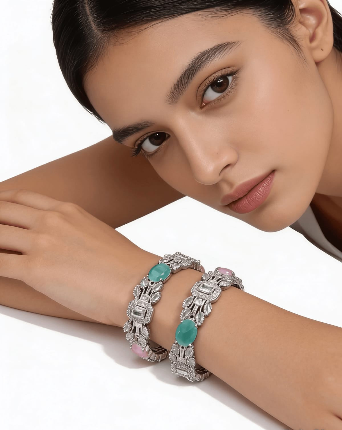 Close up of mint green and rose pink pastel stones with geometric baguette diamonds on slip-on silver bangles