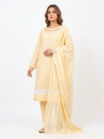 Side-angle view of a model in a pastel yellow cotton salwar kameez suit. Features a matching sheer dupatta with white lace trim, geometric cutout neckline detailing, and a lace insert on the pleated hem.