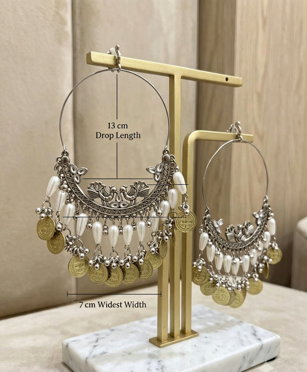Pair of Peacock Chandbali Earrings — antique silver & antique gold, white pearlescent beads, coin charms, push-back closure — measured: 13 cm drop length, 7 cm widest width — displayed on gold T-stand with marble base — Pakistani Indian bridal festive ethnic jewelry size reference.