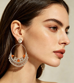 Orange worn on model: Close-up of a model wearing silver-tone peacock chandbali earrings with orange accents and dangling ghungroo fringe.