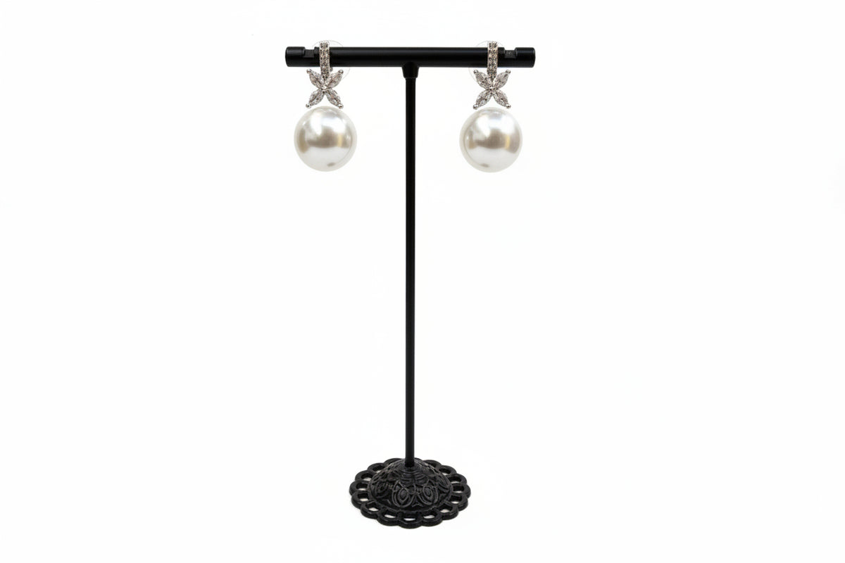 Pearls earrings displayed on a black earrings stand