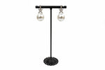 Pearls earrings displayed on a black earrings stand