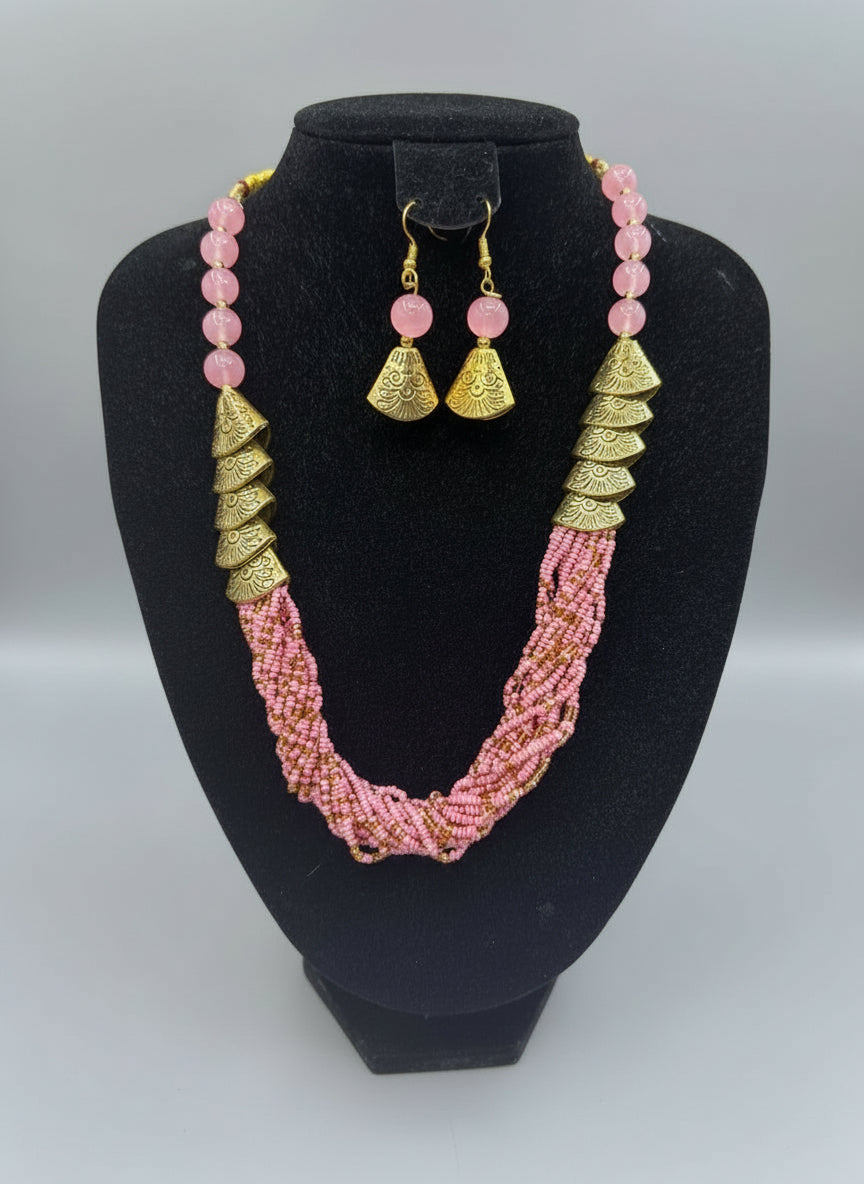 Pink beaded necklace with gold accents and matching earrings on a posh jewellery dummy.