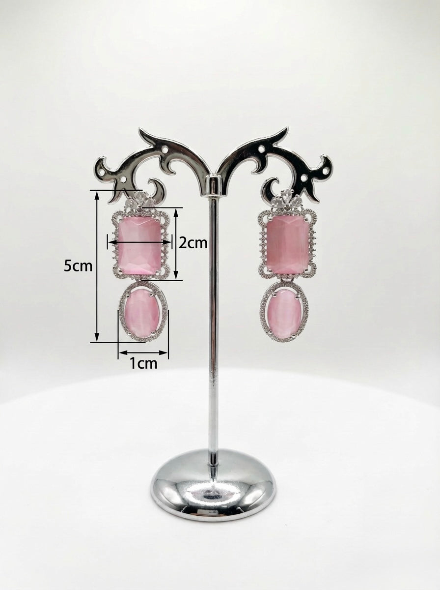 Pink earrings on a stand with measurements indicated