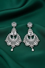 A close-up studio shot showing the back of silver-toned chandelier earrings on a black display card, featuring detailed metalwork, secure post backs, and stamped authenticity marks.