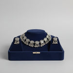 Premium silver oxidised lotus floral choker set on a display stand, highlighting the high-grade antique polish and intricate artisanal craftsmanship.
