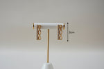 Professional shot of the Aura rose gold polish infinity bar earrings on a display stand, highlighting the brilliant AD stone clarity.