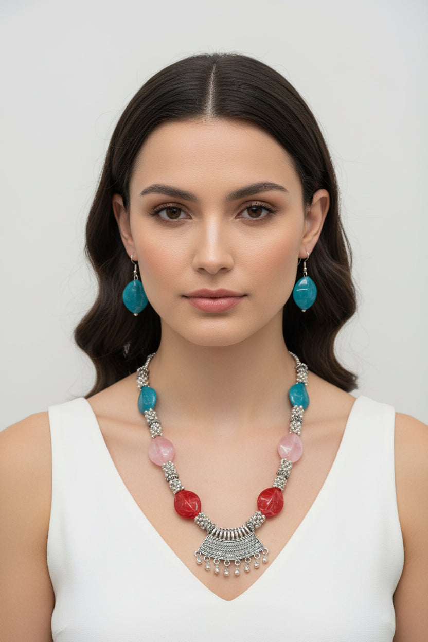Professional studio shot of a silver-plated brass bead necklace and earrings on a velvet jewelry stand; highlighting the metallic luster and premium craftsmanship of the set.