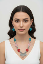 Professional studio shot of a silver-plated brass bead necklace and earrings on a velvet jewelry stand; highlighting the metallic luster and premium craftsmanship of the set.