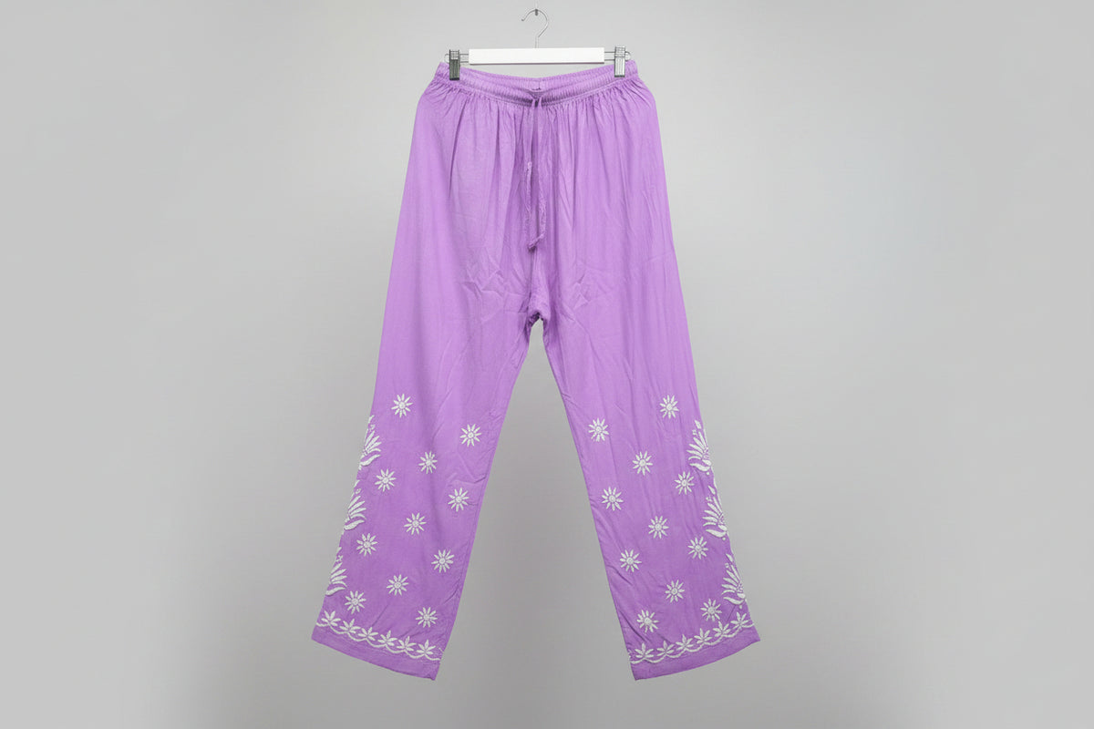 Purple straight trousers with floral white hand embroidery shown on the trousers from knee till bottom.