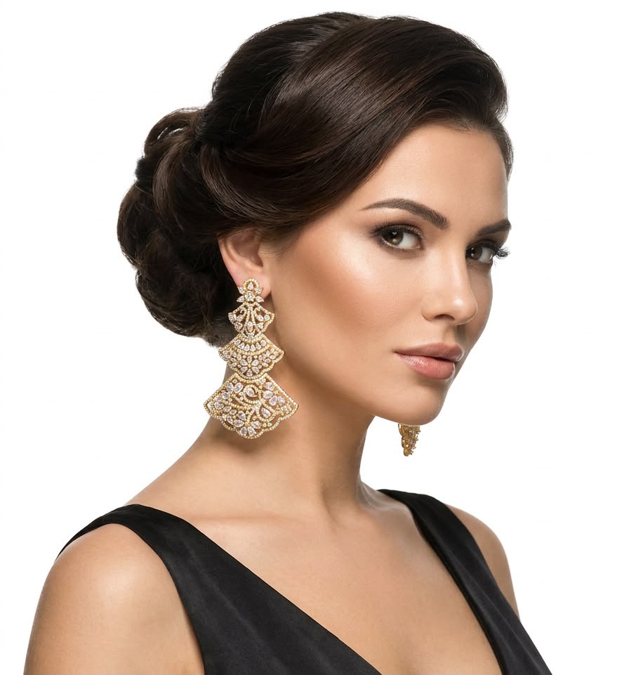A model wearing elegant three-tiered gold-tone filigree chandelier earrings with cubic zirconia, styled with an updo hairstyle for a formal look.