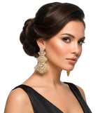 A model wearing elegant three-tiered gold-tone filigree chandelier earrings with cubic zirconia, styled with an updo hairstyle for a formal look.