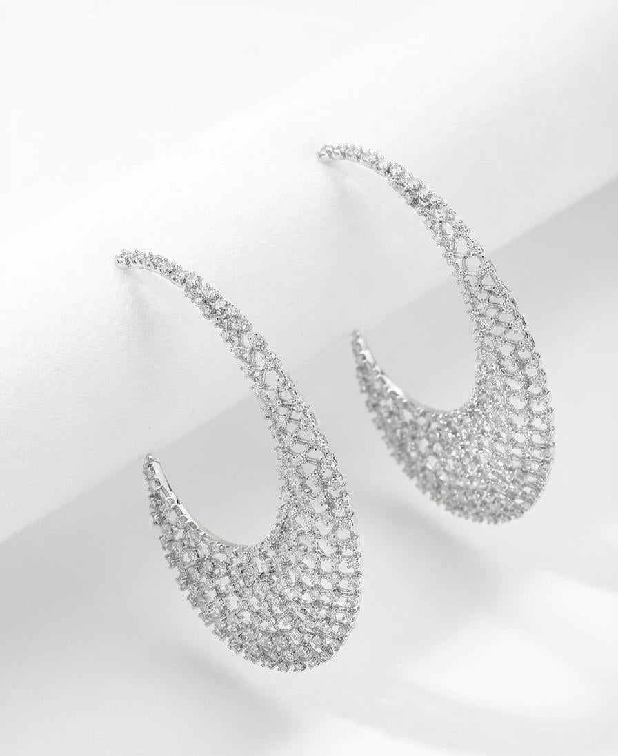 Rhodium plated statement earrings encrusted with White American Diamond (AD) stones featuring a 6cm floral lattice crescent design.