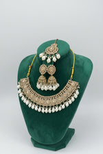 Rose gold choker necklace and 2 jhumkas with maang tikka is displayed on the dummy.