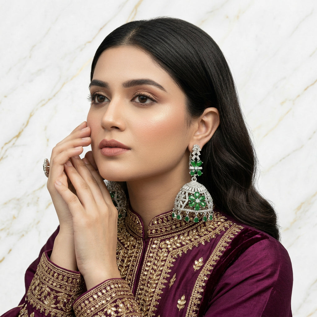 Round bali on top and jhumka in the bottom style earrings with silver AD stones and bottle green stones in flowers.