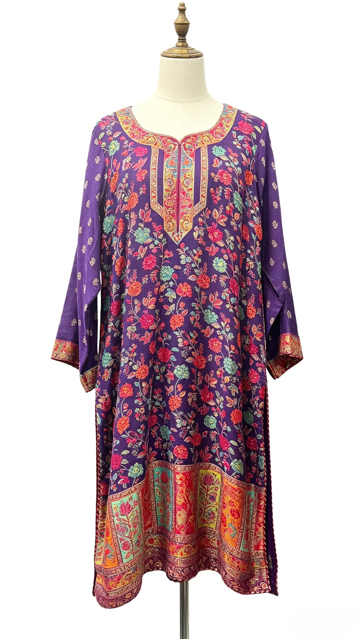 Close-up photograph of a deep purple long kurti featuring detailed multi-color floral print and embroidered neckline.