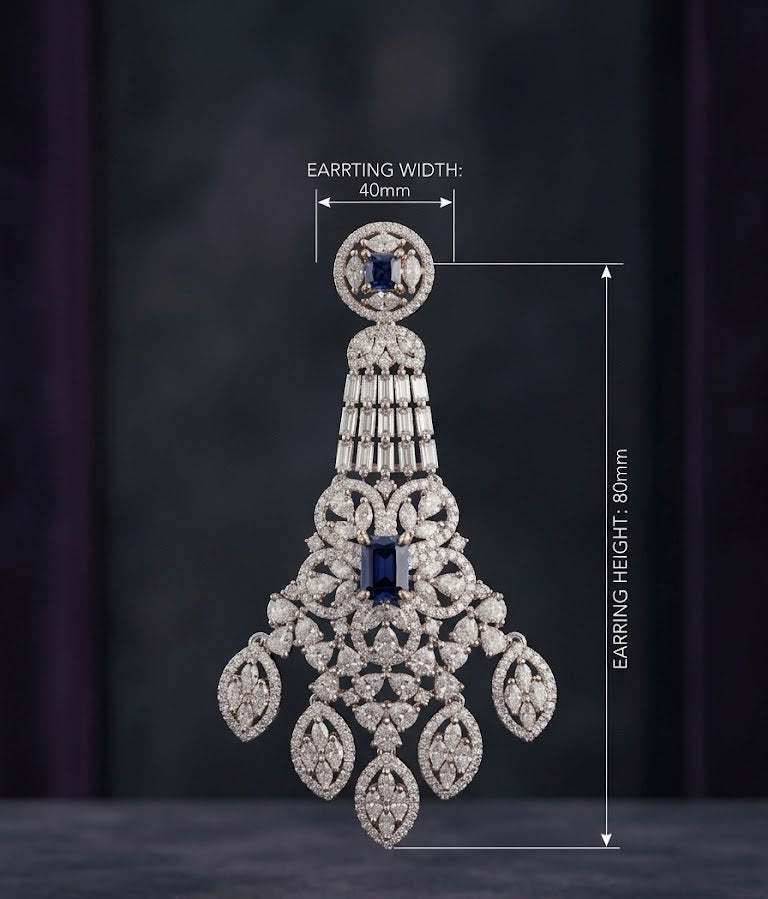 A detailed studio shot of an ornate chandelier earring featuring pavé-set diamonds and two deep blue sapphires, displayed on a stand against a black background, with specifications listing a 8 cm drop, 4 cm width, and 20-gram weight.