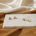 Set of gold triangle earrings on a CZ Jewellery card with a reflective surface background.