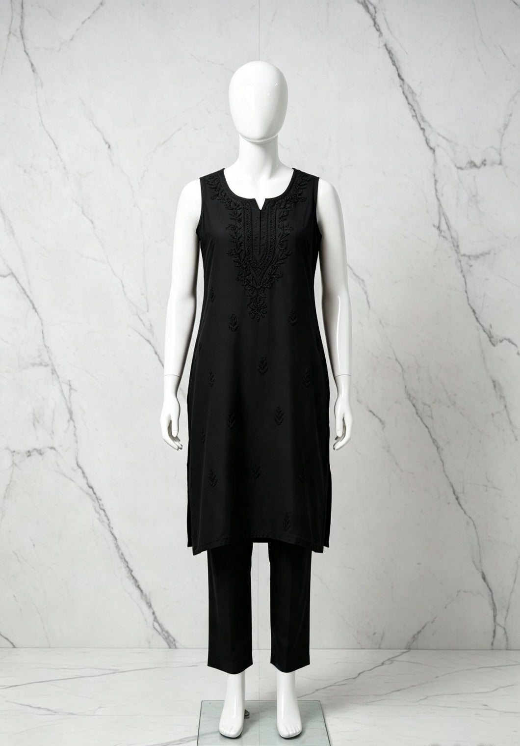 Full-length front view of the black handcrafted sleeveless Chanderi silk Chikankari co-ord set displayed on a mannequin against a white marble background.