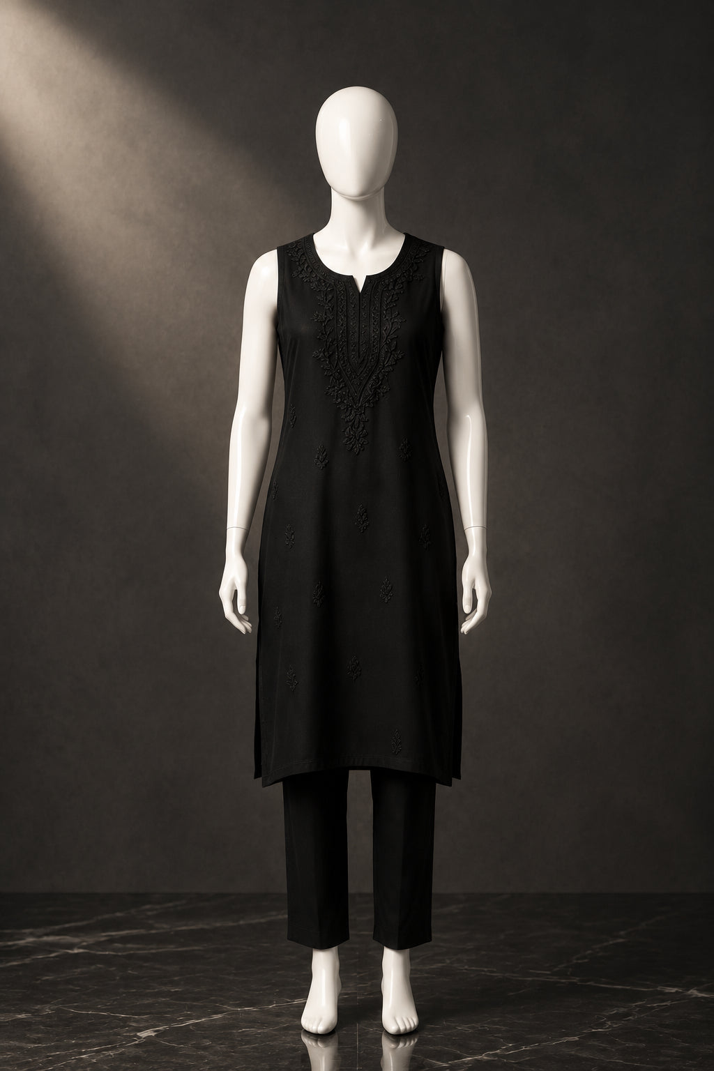 Full-length front view of the black handcrafted sleeveless Chanderi silk Chikankari co-ord set displayed on a mannequin against a white marble background.