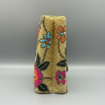 Side view of The beige-coloured floral handcrafted tote bag with glass bead embroidery and an internal strap.