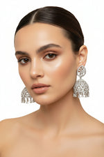 Silver-toned bridal Jhumka earrings with high-shine crystal worn by our model.