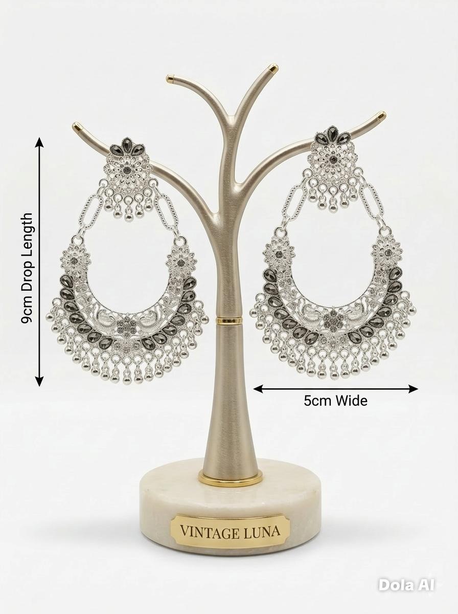 Silver-toned evening earrings with a wide, decorative silhouette and textured filigree design with measurments.