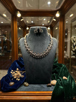 Silver coated oxidised alloy necklace featuring a continuous deer trail design on a premium display stand.