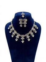 Silver jewelry set with necklace and earrings on a blue mannequin bust.
