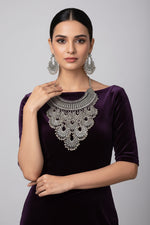 Silver necklace and earrings set on a black mannequin bust with a white background