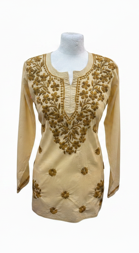 Creamy beige cotton short kurti featuring intricate dark yellow-brown floral embroidery along the neckline and scattered motifs across the front, displayed on a mannequin.