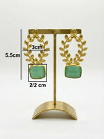 Statement earrings featuring an emerald green sugar stone with detailed floral carvings and golden accents with measurments.