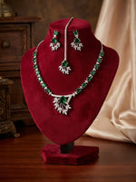 The American diamond jewellery set including necklace, earrings and maang tikka with bottle green centre stone.