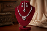 The American diamond jewellery set including necklace, earrings and maang tikka with white centre stone.