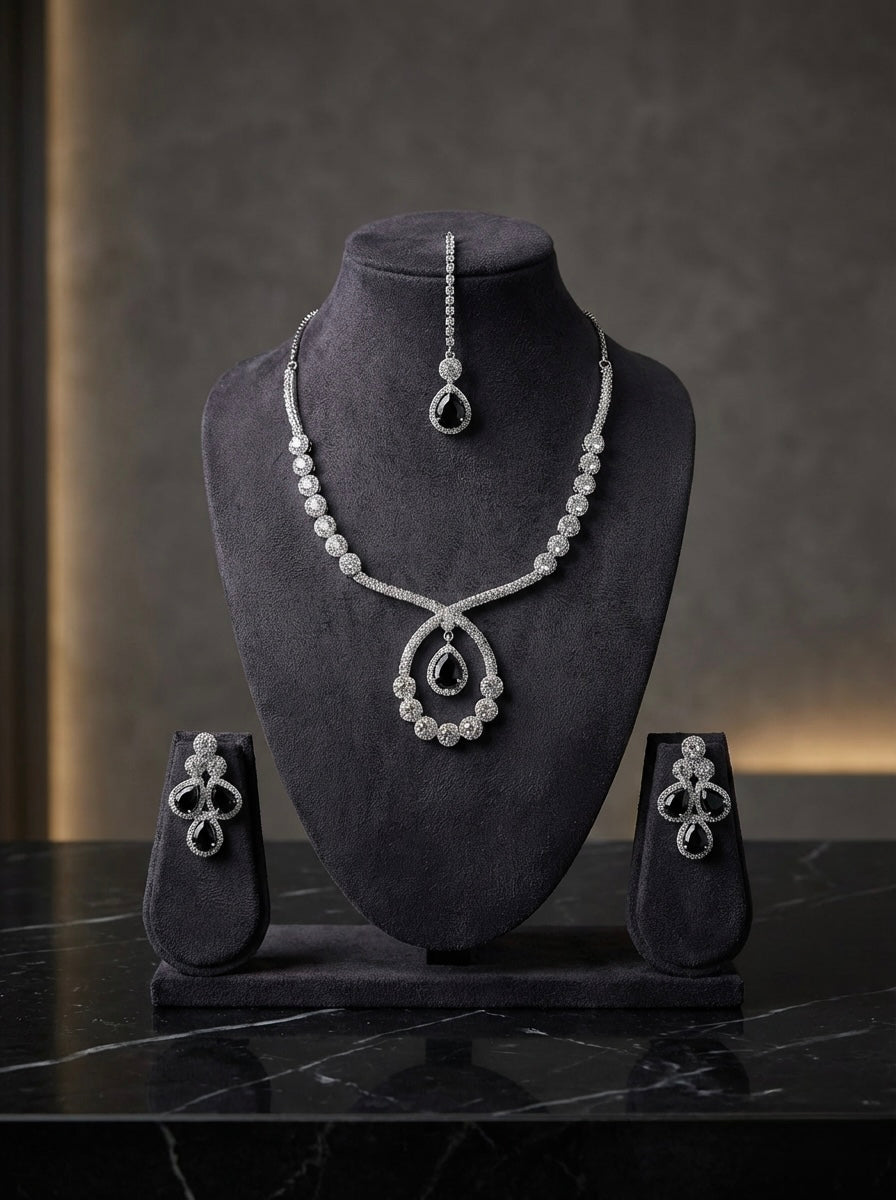 The American diamonds bridal jewellery set including necklace, earrings and maang tikka with black central cubic zirconia stones.