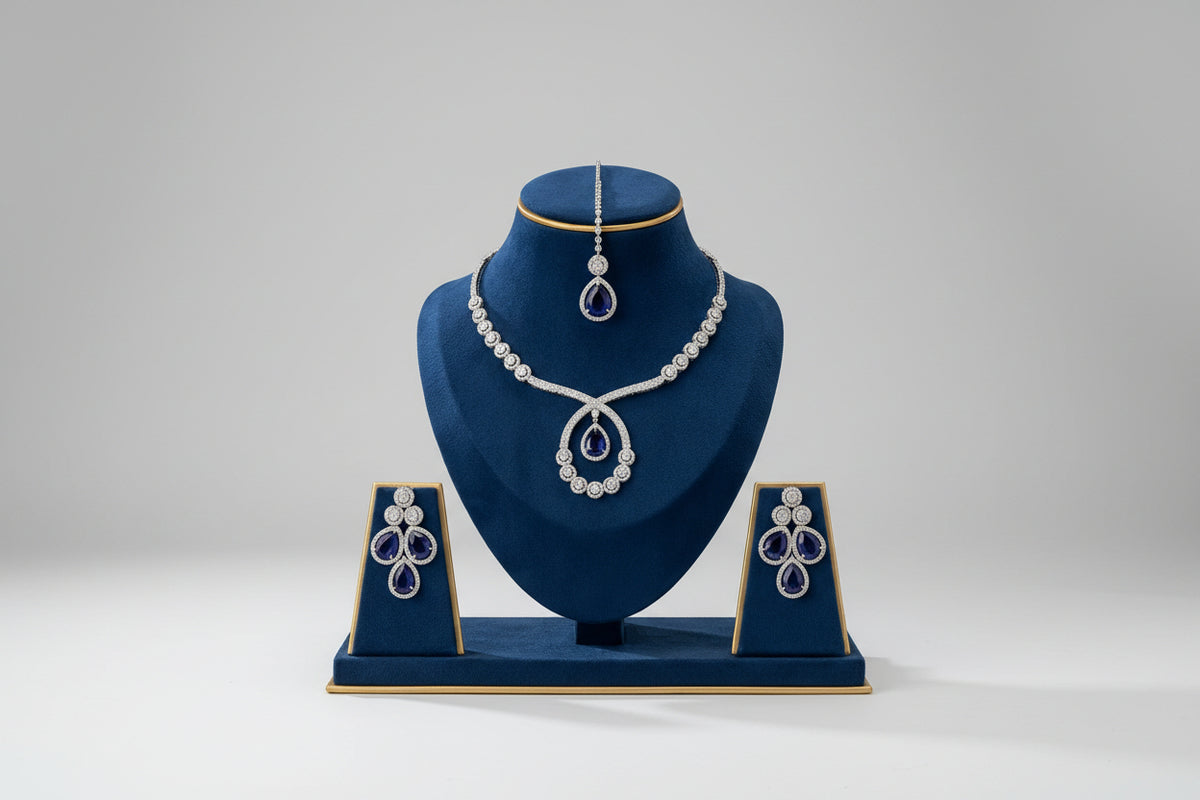 The American diamonds bridal jewellery set including necklace, earrings and maang tikka with purple colour central cubic zirconia stones