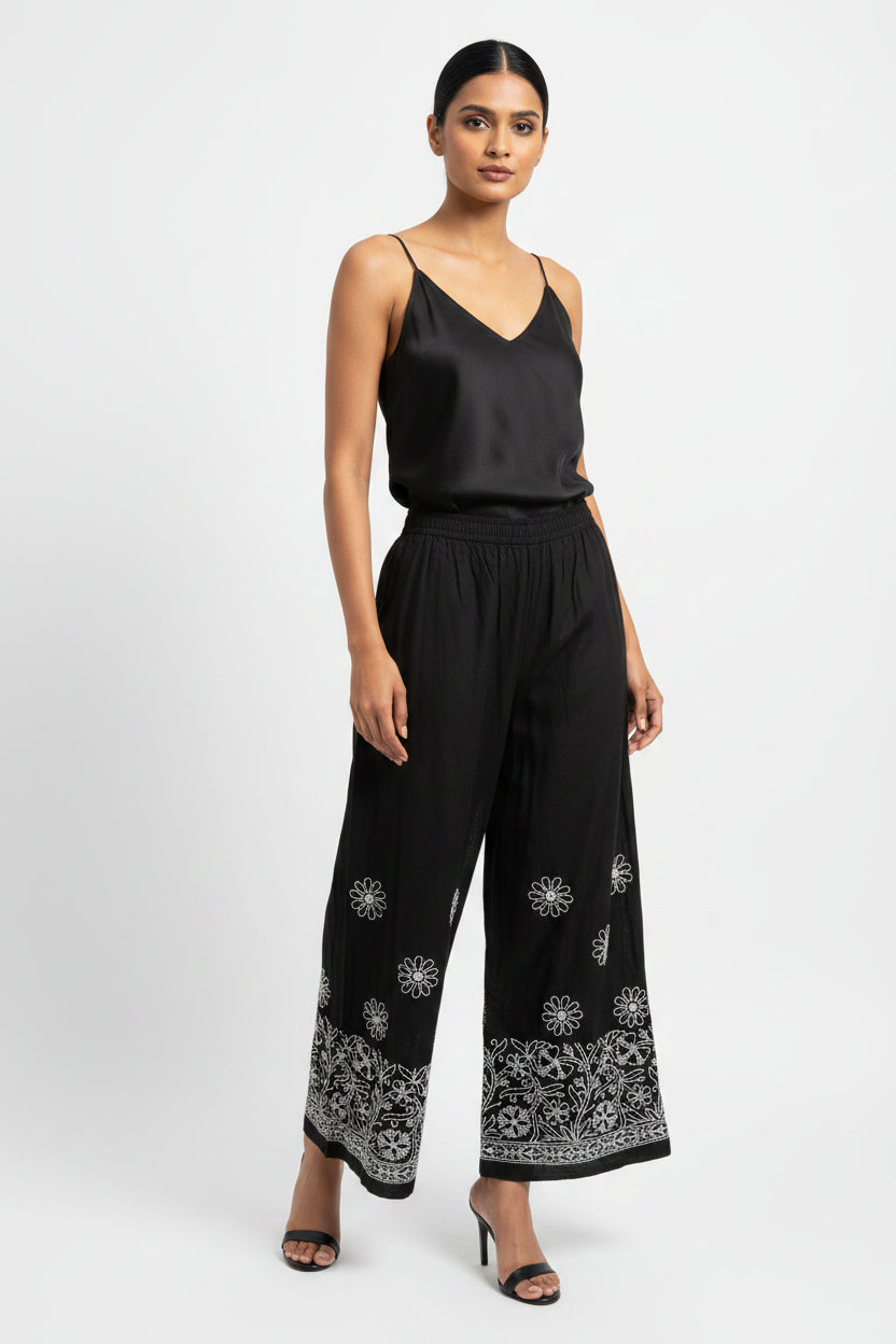 Close up white Chikankari paisley hand embroidery on black cotton flared pants
